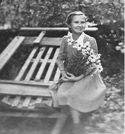 Young Ilga Vise sitting on a sled her father constructed to carry their few belongings as they fled.